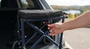Close-up view demonstrating the easy-folding mechanism of a compact portable wheelchair for travel.