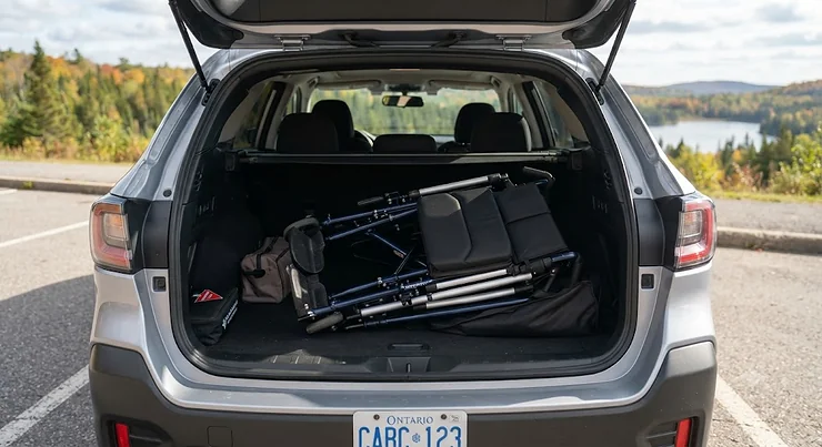A lightweight portable wheelchair for travel neatly folded and stored in the trunk of a car for a Canadian road trip.