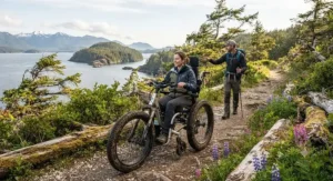 An electric-assist trail wheelchair helping wheelchair hikers ascend a gentle woodland slope.