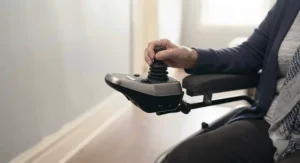 Ergonomic joystick control on an indoor power wheelchair for precise navigation in tight spaces.
