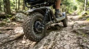 A heavy duty power wheelchair demonstrating advanced suspension while rolling over rough terrain.